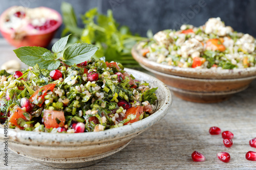 Tabbouleh salad with parsley, mint, bulgur and pomegranate. Fresh salad with herbs. photo