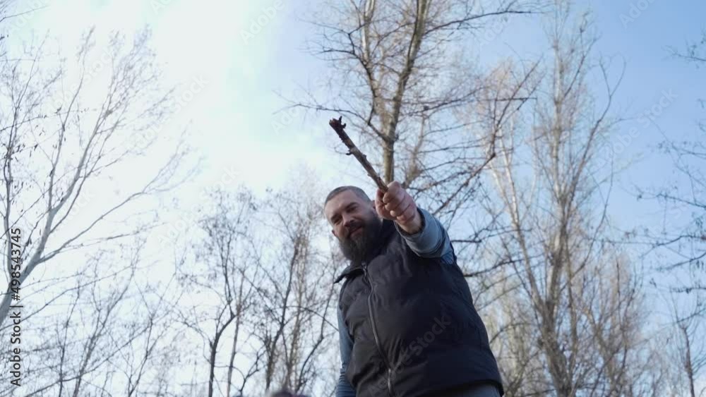 Man Plays with His Dog Outdoors. Funny Dog Hops and Bites Wooden Stick His Owner Holds. Slow Motion Man Plays with His Dog Outdoors. Funny Dog Hops and Bites Wooden Stick His Owner Holds. Slow Motion