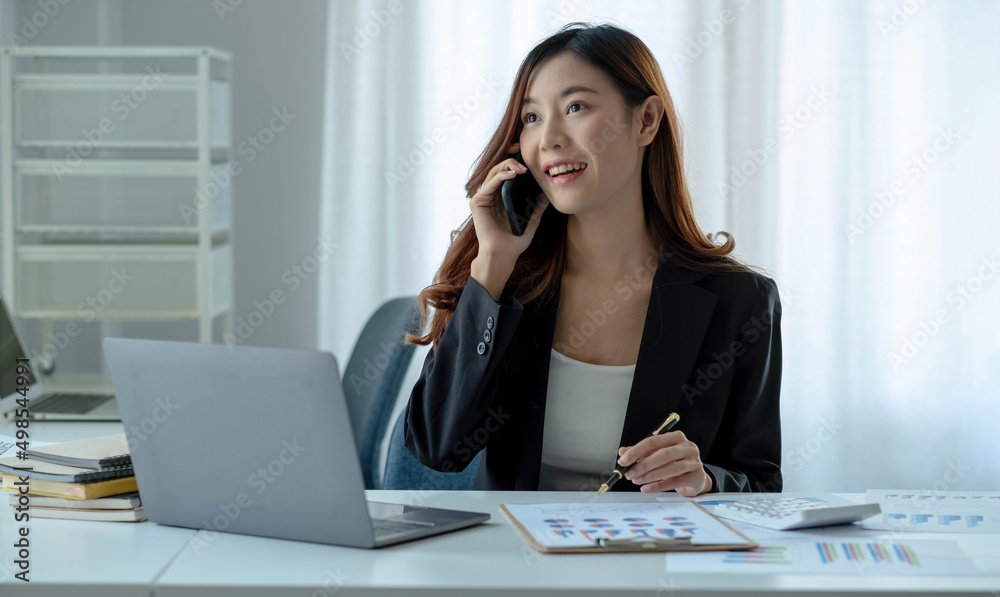 Asian business woman have the joy of talking on the phone, laptop and tablet on the office desk. Asian business woman have the joy of talking on the phone, laptop and tablet on the office desk.