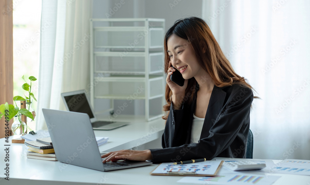 Asian business woman have the joy of talking on the phone, laptop and tablet on the office desk. Asian business woman have the joy of talking on the phone, laptop and tablet on the office desk.