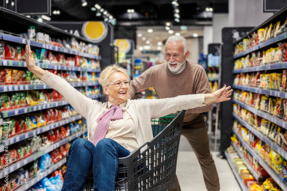 A senior couple having fun at supermarket.