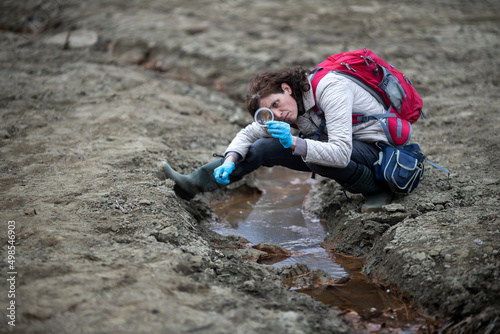 Mid Adult Biologist Examining Samples of Terrain On Location