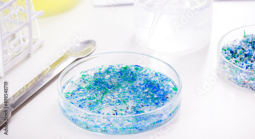 hand of traces of plastic and microplastic in petri dish, analyzed in laboratory, study of environmental problem
