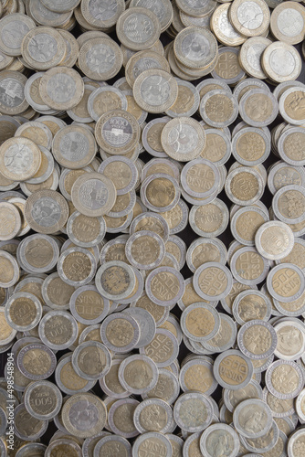 Pile of Colombian coins of 500 and 1000 denominations over wooden background. Ideal for economy  money  banks  save money and finance. 