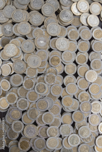 Pile of Colombian coins of 500 and 1000 denominations over wooden background. Ideal for economy, money, banks, save money and finance. 