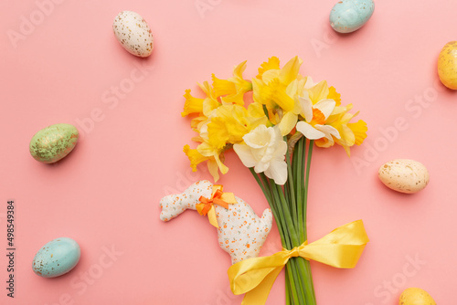 Light yellow spring bouquet and easter decor on pink background. Spring flowers background with copy space