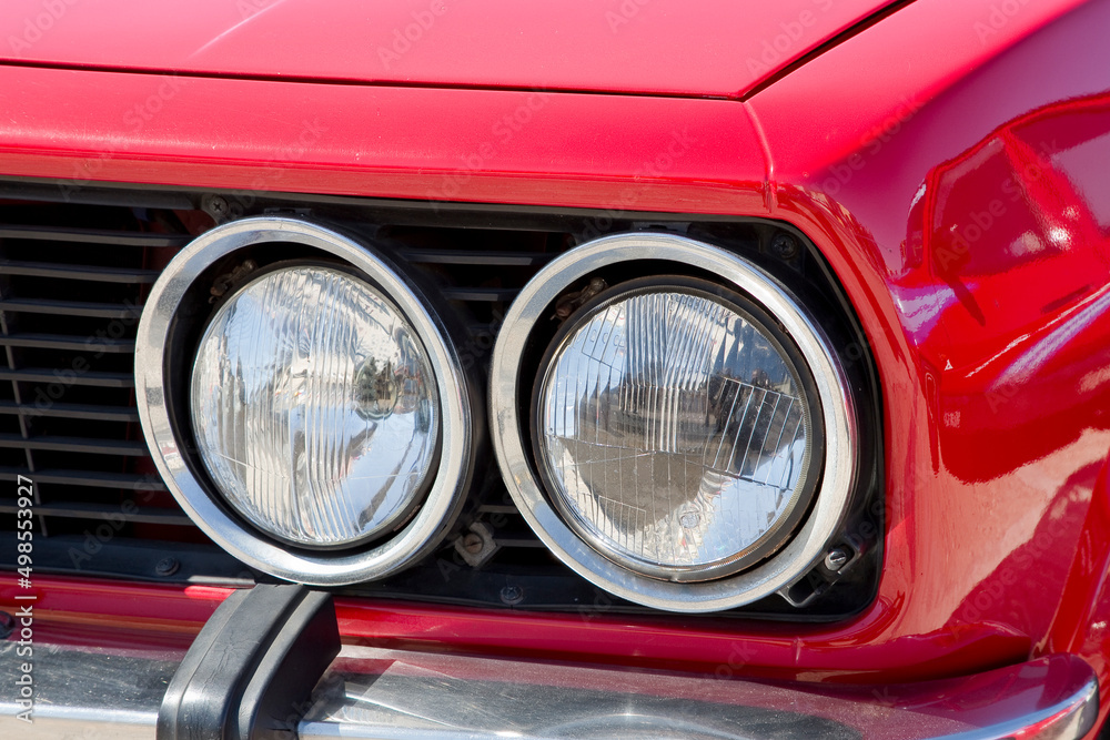 Detail of an headlight of a vintage italian red sport car
