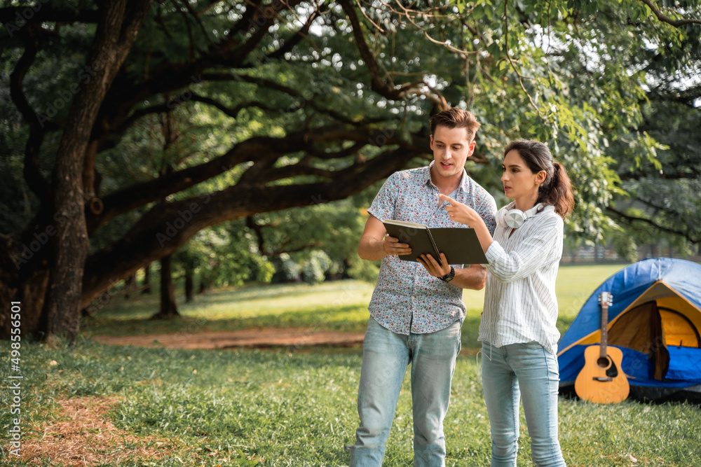 Fototapeta premium Young couple walking in the park with the romantic feeling. Love and tenderness, Romantic man smiling to his girlfriend, lifestyle concept