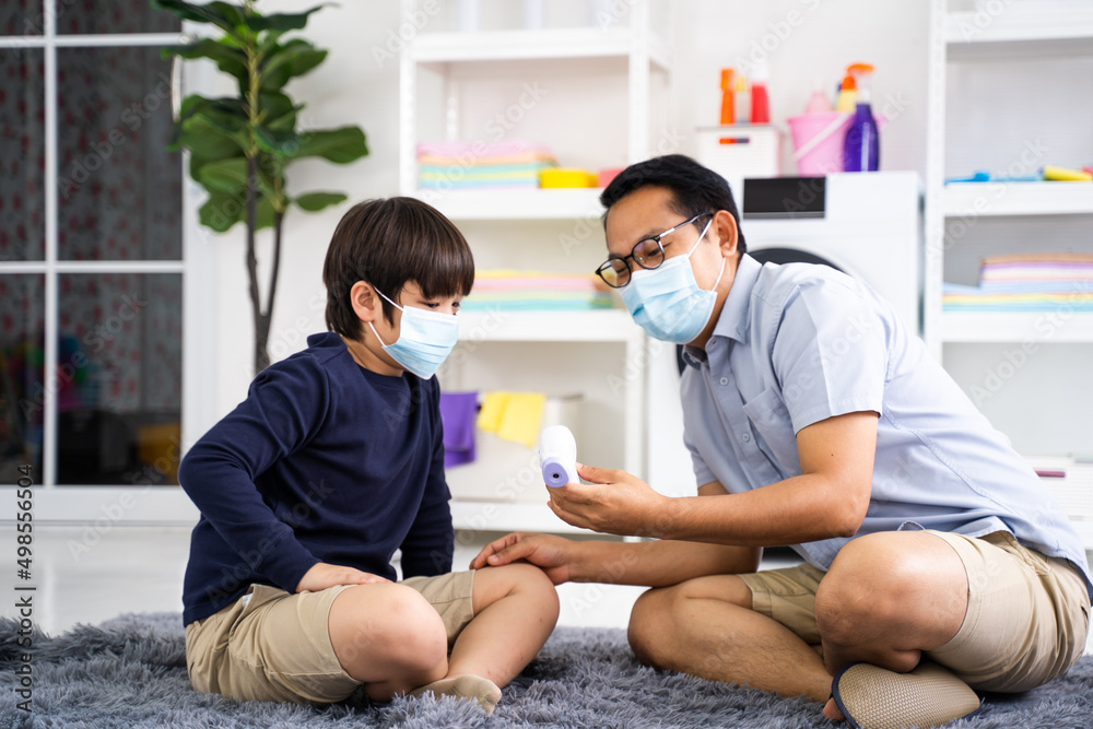 Obraz premium Father puts on son medical face mask in home Coronavirus quarantine and epidemic, Family wearing face mask for protection during the quarantine
