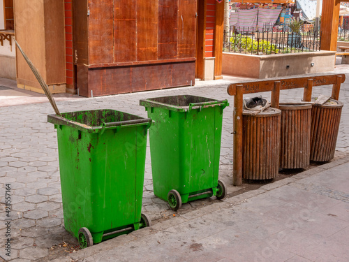 Garbage bins and garbage collection containers on city streets.