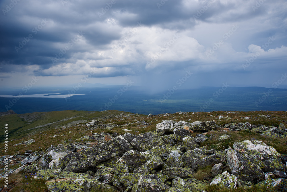 green mountains covered with forest, storm clouds, view from the top with stones green mountains covered with forest, storm clouds, view from the top with stones
