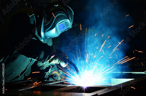 Workers wearing industrial uniforms and Welded Iron Mask at Steel welding plants, industrial safety first 