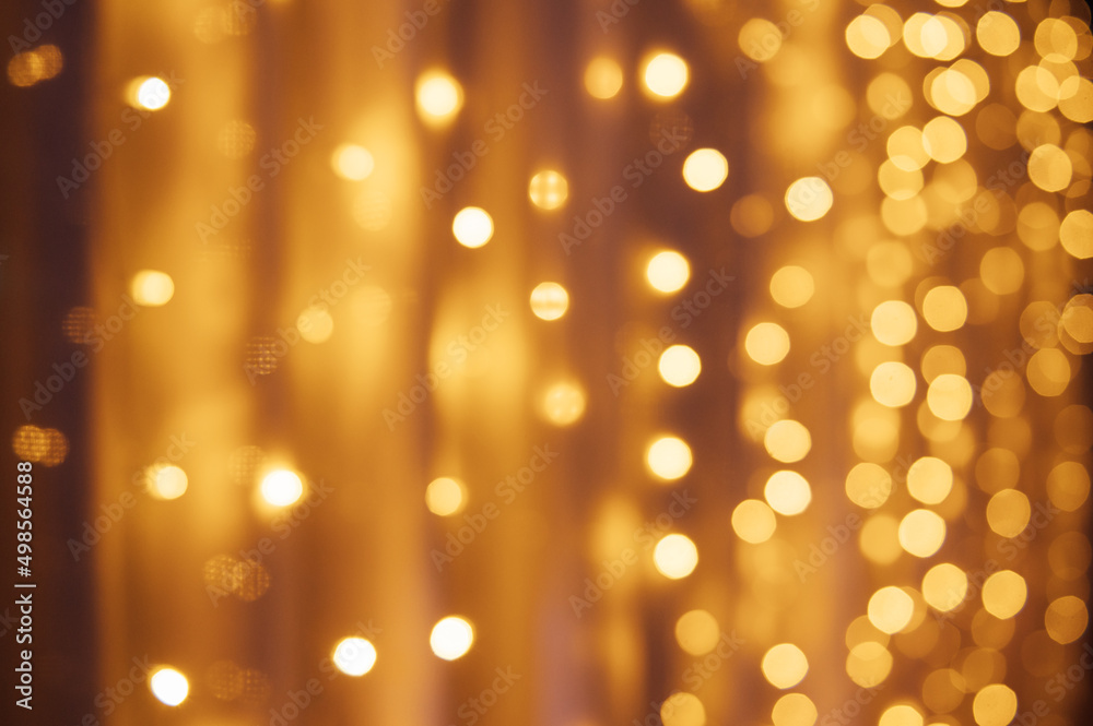 Abstract defocused yellow light on black background. Bokeh photo of LED light.
