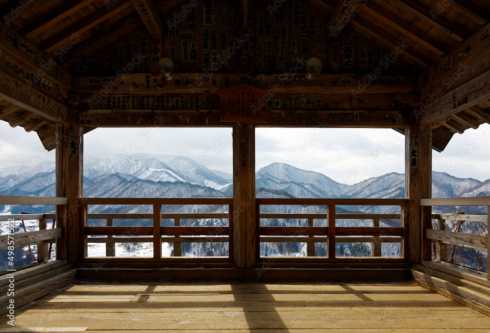 A scenic view overlooking the winter mountains covered with snow from inside Godaido Hall, one of the historical wooden architectures in Risshaku-ji Buddhist Temple in Yamadera, Yamagata, Japan