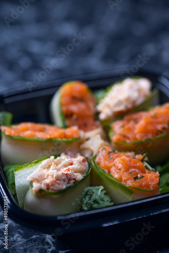 set of sushi rolls with seafood on a black stone background