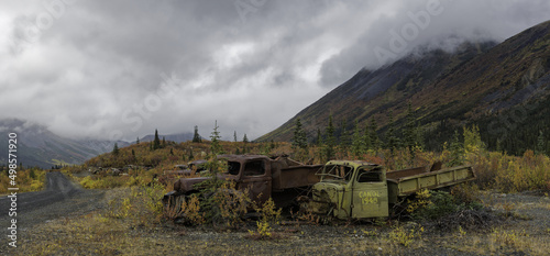 Fall colors and mountains surround WWII truck grave yard at McMillan Pass, Yukon Canada photo