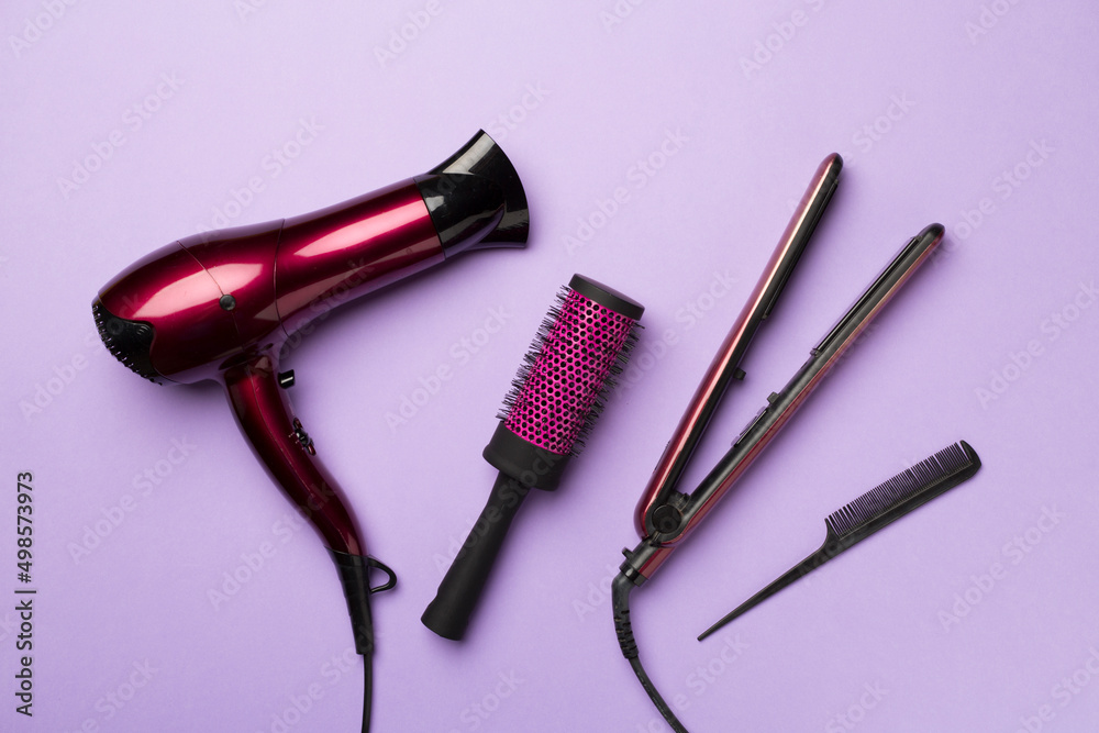 Hair dryer, straightener and brush on color background, top view Stock  Photo | Adobe Stock