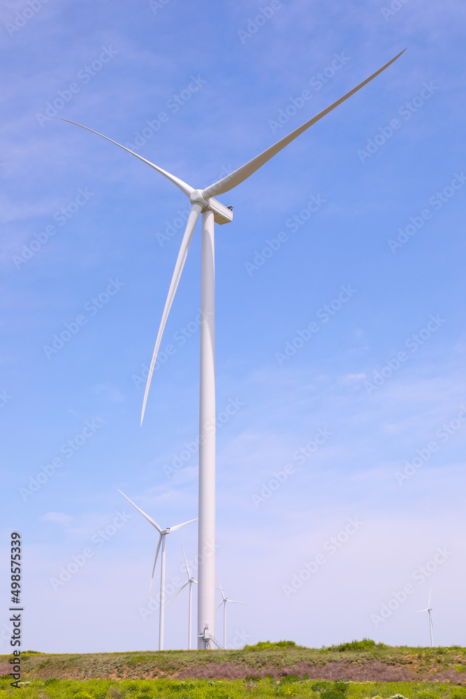 Wind turbines against the backdrop of a sunny sky. Green ecological energy generation. Eco field wind farm Wind turbines against the backdrop of a sunny sky. Green ecological energy generation. Eco field wind farm