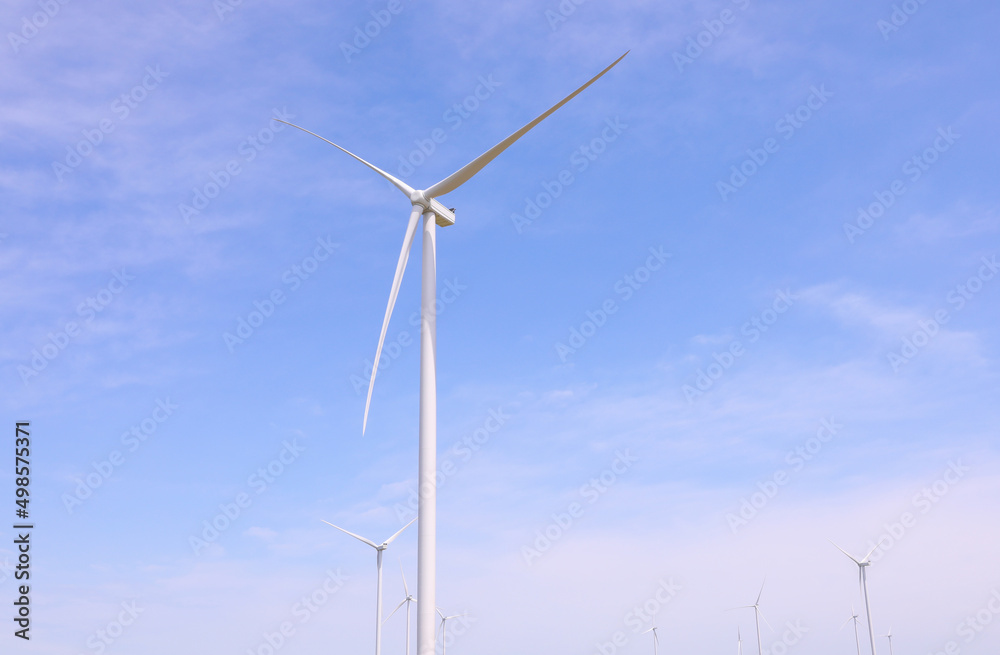 Wind turbines against the backdrop of a sunny sky. Green ecological energy generation. Eco field wind farm