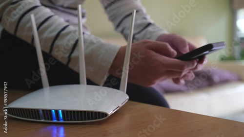 Selective focus at router. Internet router on working table with blurred man using tablet at the background. Fast and high speed internet connection from fiber line with LAN cable connection.