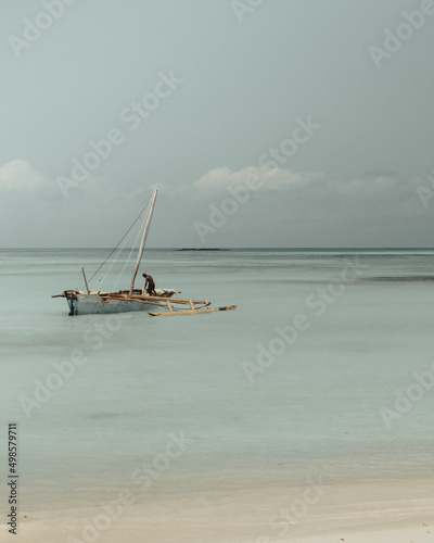 Vertical shot of a person in a sailboat near the beach photo