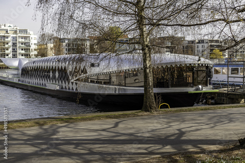 Small cruise ship near the dock on a sunny day at the Treptower Park in Berlin, Germany photo