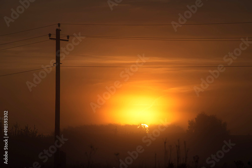 Silhouette of old electrical lines, old telephone cables and light at the golden hour on the sunrise. © sergofan2015