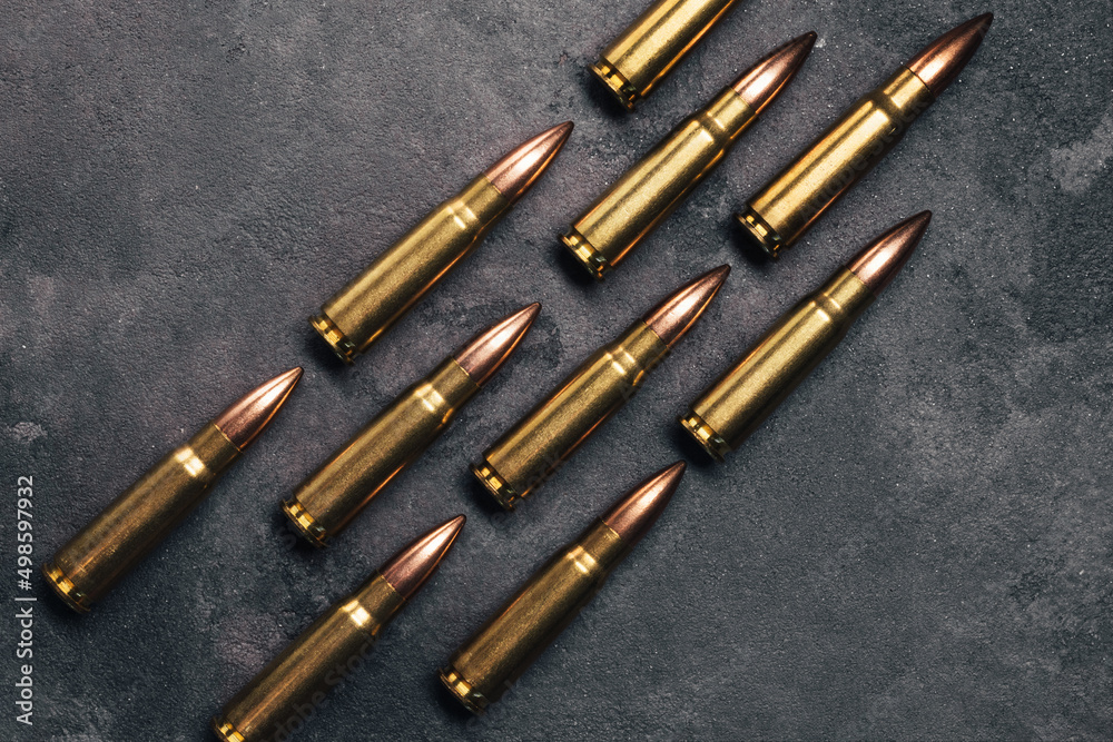 Bullets on gray background. Cartridges 7.62 caliber for Kalashnikov assault rifle. Top view, flat lay Bullets on gray background. Cartridges 7.62 caliber for Kalashnikov assault rifle. Top view, flat lay