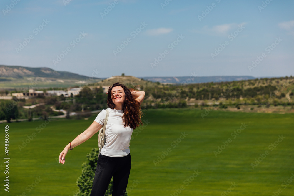 woman traveler climbs to the top of a mountain nature