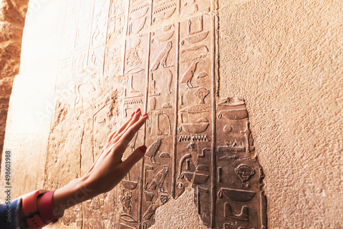 An Egyptologist or archaeologist reads and translates Egyptian hieroglyphs carved in stone photo