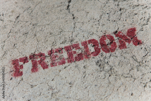 The word FREEDOM stencil graffiti on concrete wall photo