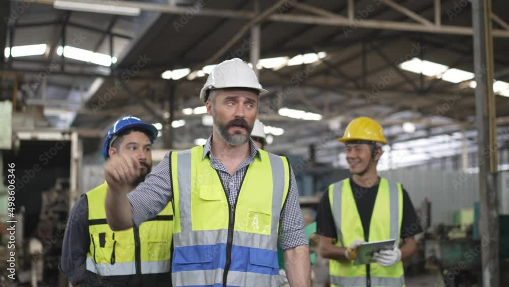 Male engineer foreman walking and explaining project to group of mechanic or technician trainee at the industry factory. Training new staff workers. Male engineer foreman walking and explaining project to group of mechanic or technician trainee at the industry factory. Training new staff workers.
