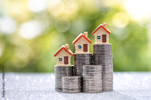 House model placed on top of the growth direction coin. Investing in real estate business for profit or a loan for a home purchase concept.