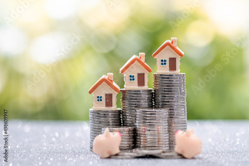 House model placed on top of the growth direction coin. Investing in real estate business for profit or a loan for a home purchase concept.