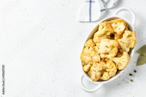 Crispy BBQ beer battered cauliflower nuggets  in baking dish. Space for text.