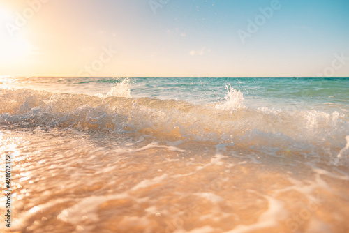 Closeup waves and sea sand, paradise beach landscape. Inspire tropical beach seascape horizon. Orange and golden sunset sky, blurred calmness tranquil relaxing sunlight summer. Vacation travel holiday