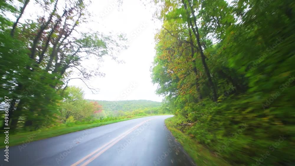 Point of view pov car vehicle driving shot at Blue Ridge Parkway road, Virginia at fall autumn colorful foliage on Appalachian mountains national park forest with mist fog Point of view pov car vehicle driving shot at Blue Ridge Parkway road, Virginia at fall autumn colorful foliage on Appalachian mountains national park forest with mist fog