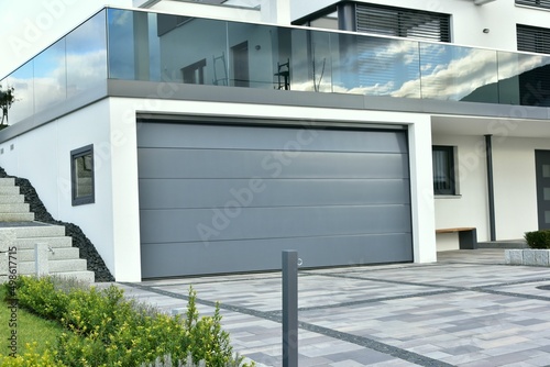 Moderne Beton-Garage, Carport,  mit Automatik-Tor in der Hauszufahrt photo