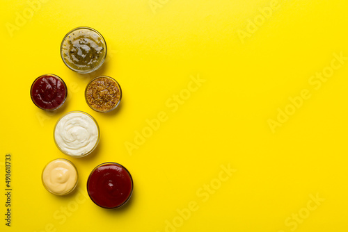 Different types of sauces in bowls on a colored Board . Top view. various sauces copy space photo