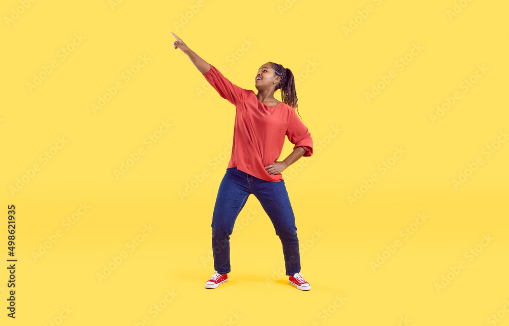 Funny young African American woman isolated on yellow studio background dance in casual clothes. Smiling millennial black girl have fun make dancer moves enjoy celebration or party. Funny young African American woman isolated on yellow studio background dance in casual clothes. Smiling millennial black girl have fun make dancer moves enjoy celebration or party.