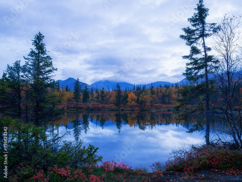 Reflection of mountains and clouds in the calm surface of the lake. Peaceful landscape. Khibiny