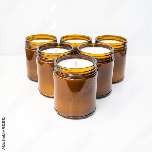 Six amber colored jar candles in a triangle formation 