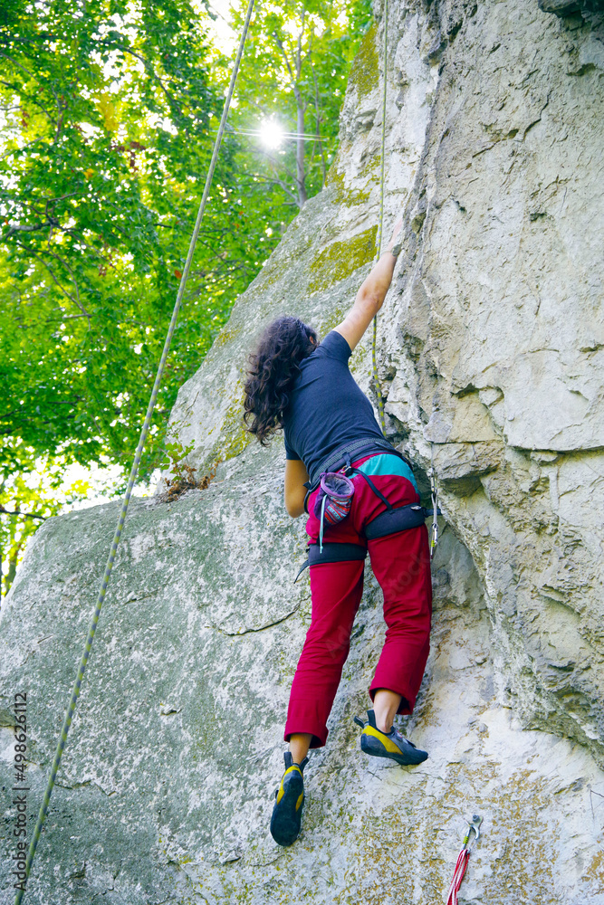 Young woman climbing on a big limestone wall
