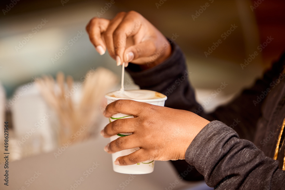 Obraz premium Starting the day with a good cup of coffee. Shot of an unrecognizable person stirring a cup of coffee.