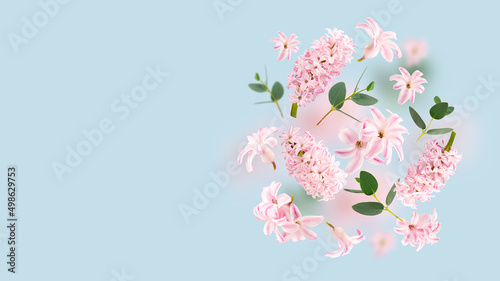 Rose hyacinth flowers and green leaves flying in the air on spun sugar background. Levitation concept. Floating petals on a light blue. Postcard with wedding, women's day, mother's day. Copy spase