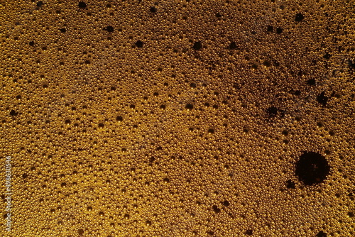 Beer foam texture. Bubbles irradiated with light. Roughened surface.
