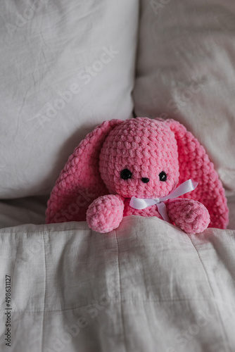 Knitted pink-colored bunny in the interior of a bright apartment