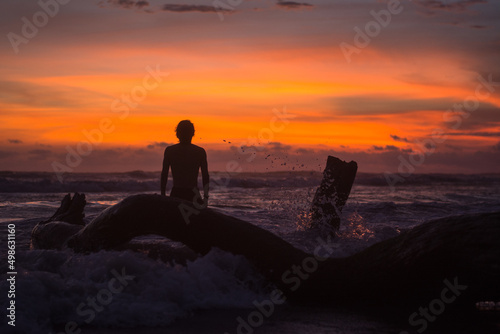 silhouette of a person sitting on a rock