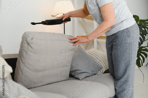 Portrait of senior woman with vacuum cleaner indoors at home  hoovering