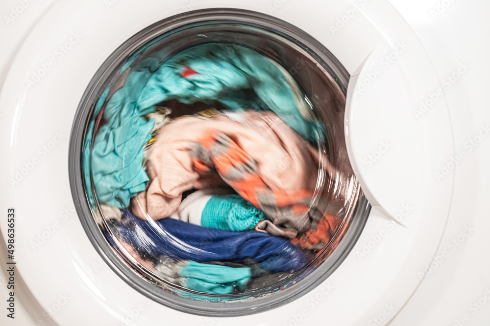 The process of washing different clothes in the washing machine The process of washing different clothes in the washing machine